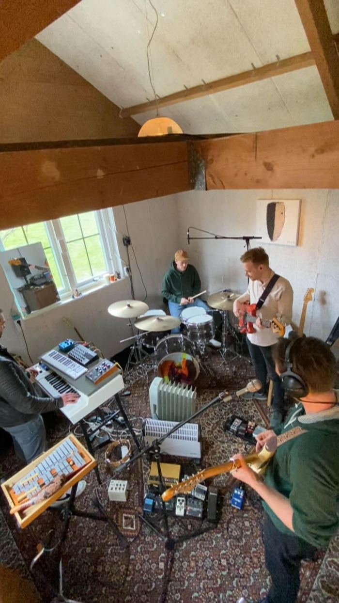 Overhead view of the band recording in the garage, surrounded by amps and keyboards