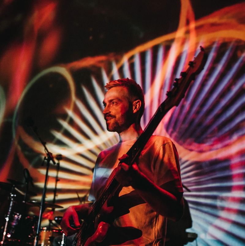Guitarist in front of swirling projected light